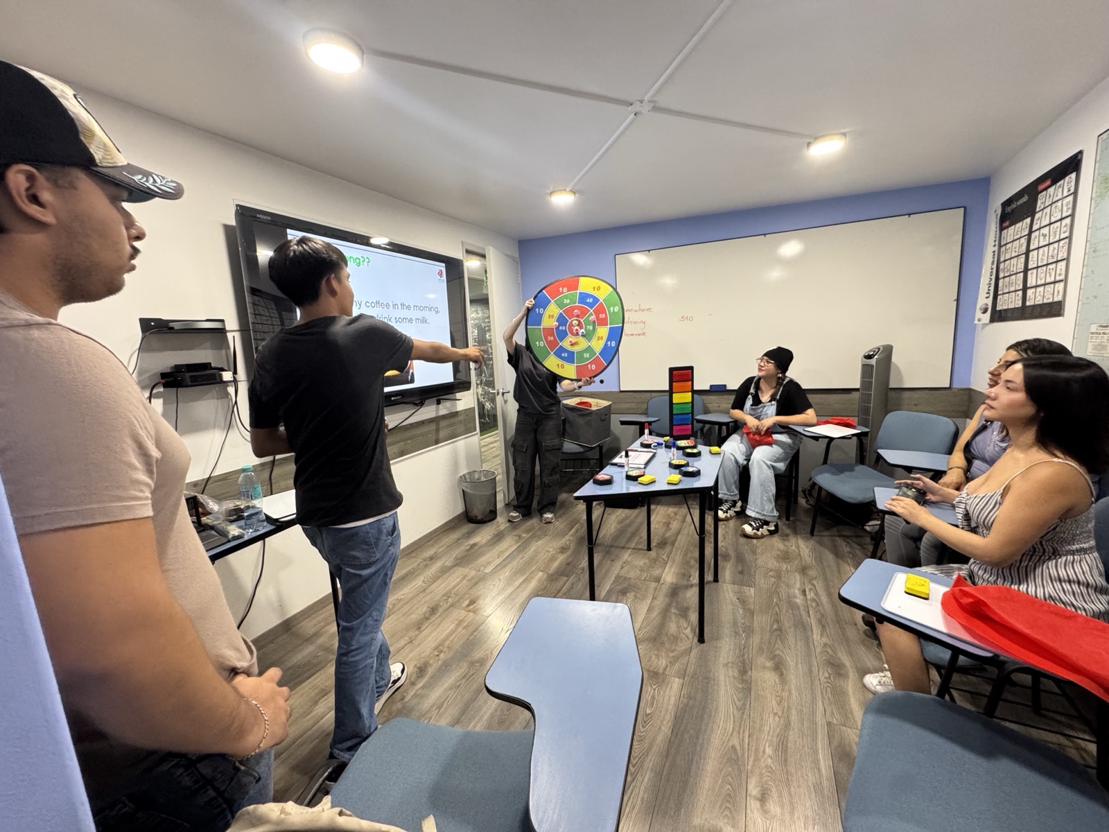 Clase presencial en Universal House: alumnos participando con dinámicas en el salón